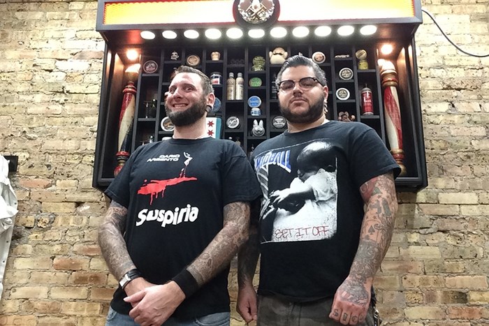 Evil Barber Pete and Evil Barber Mike pose in front of the pomade store at Pete's Barbershop.